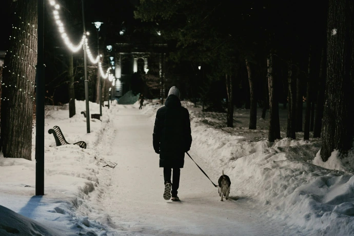 person in black coat walking on snow covered ground during daytime